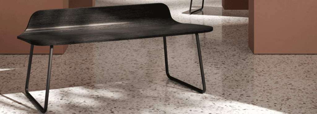 Modern black Kendra Bench with a natural oak shell and black metal frame in a waiting area.