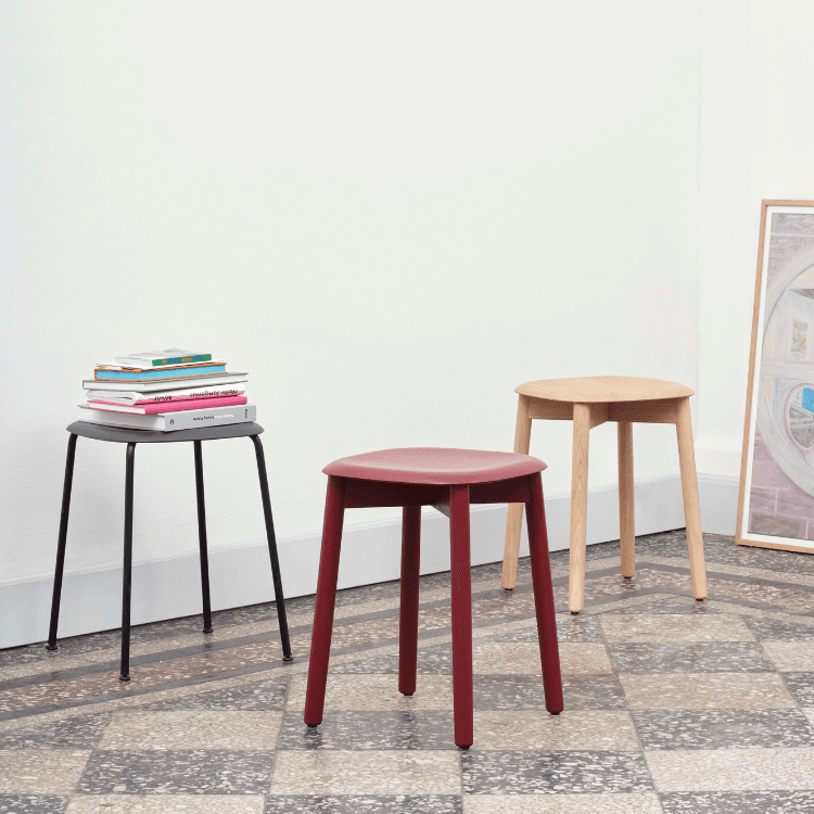Three HAY Soft Edge 72 stools in black, red, and natural wood finish. Minimalist design for modern Cyprus interiors.