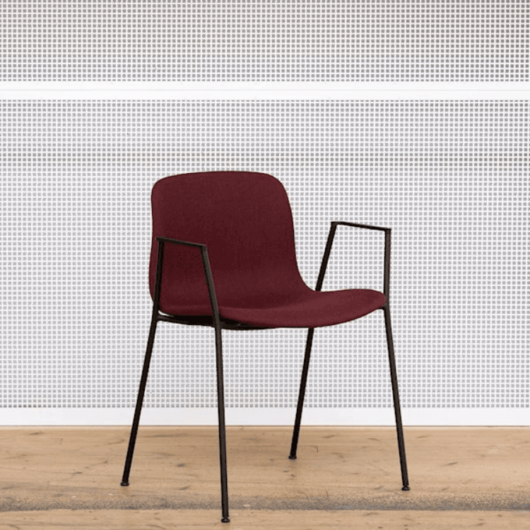 Burgundy AAC 19 chair by HAY. Fully upholstered with slim, black metal legs and integrated armrests.