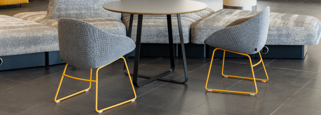 Two Always Side Chairs with orange frames, paired with a table and sofa.