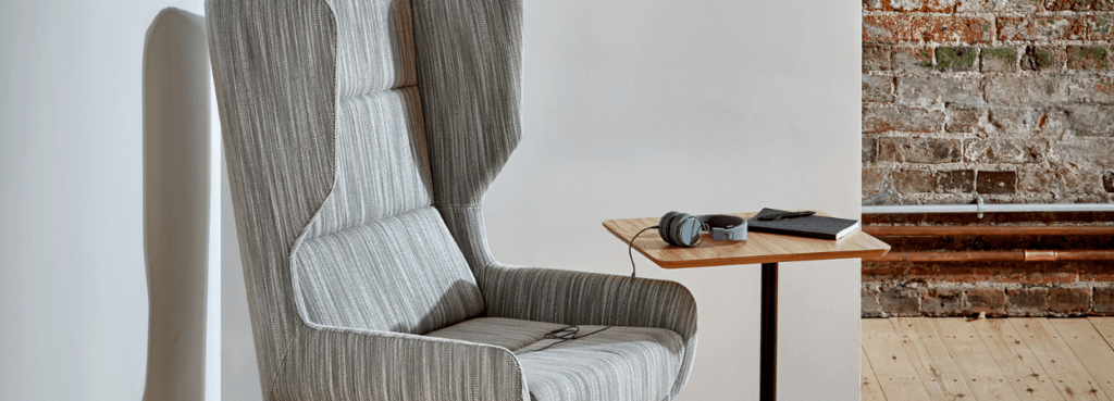 Stylish Hush Chair in gray fabric with a high backrest, offering comfort and privacy for modern spaces.