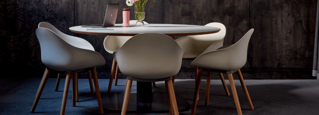 Modern Ruby Side Chair in light gray with wood legs around a white table.