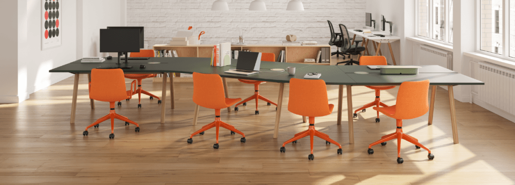 Modern office space featuring orange Viv Chairs around a long green table.