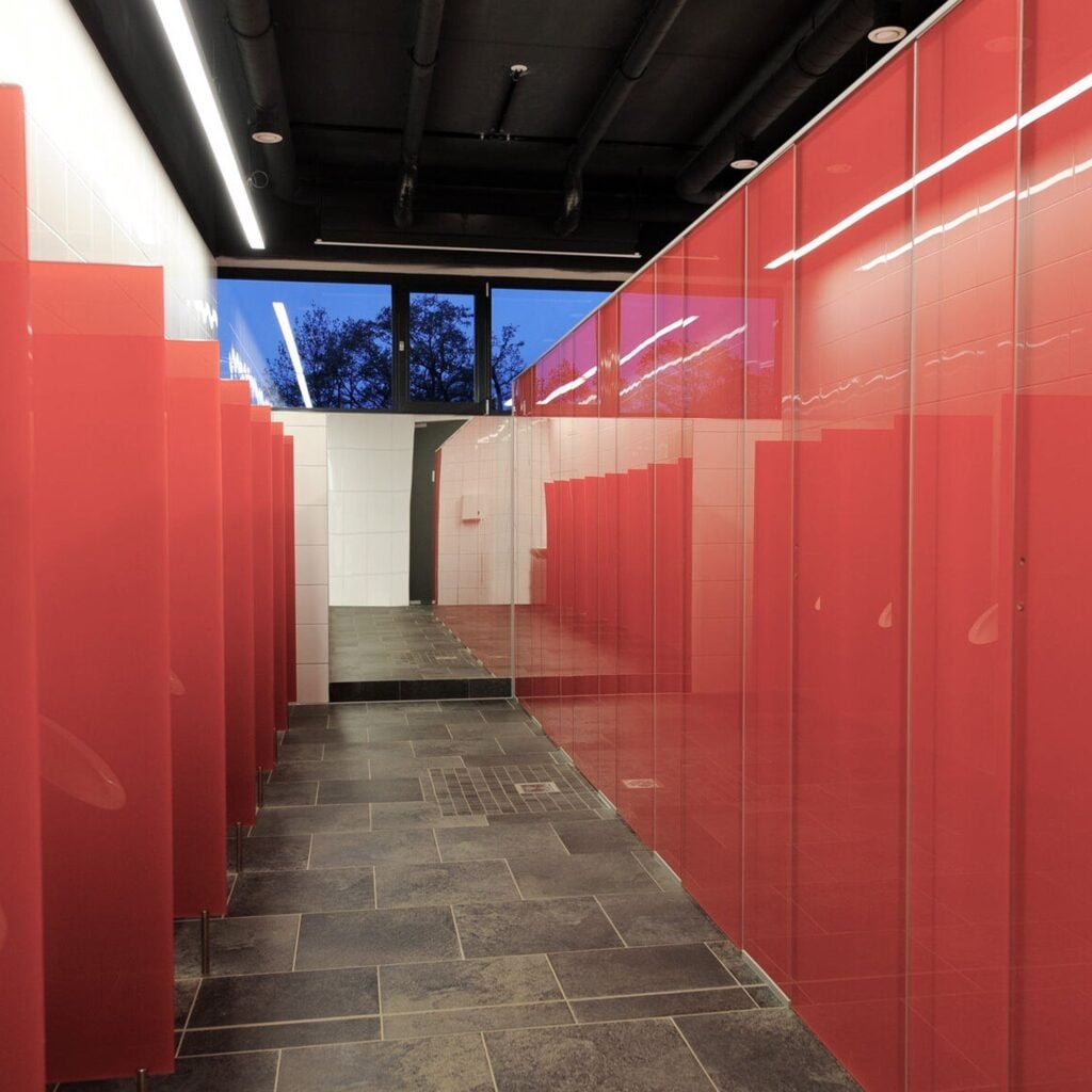 Long run of red glass toilet cubicles