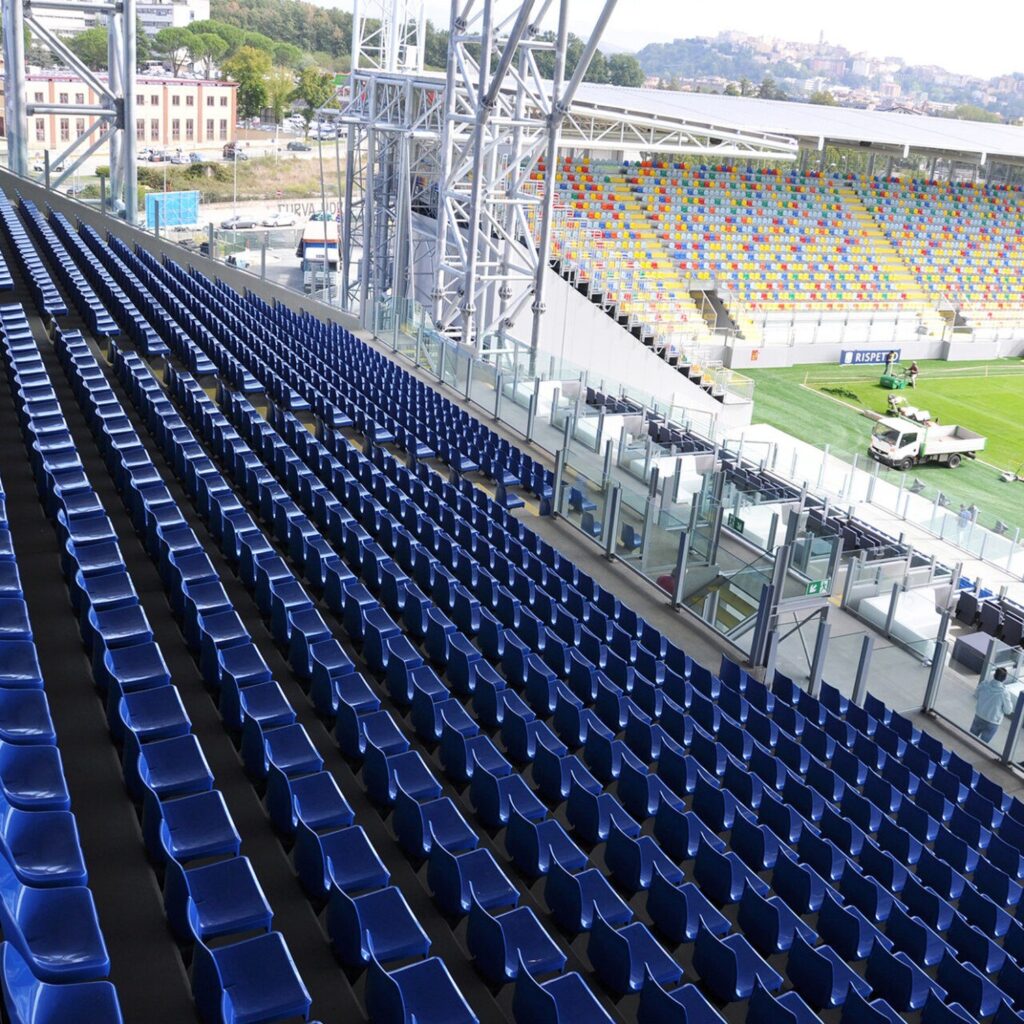 Rows of dark-blue high-back seats in a stadium stand