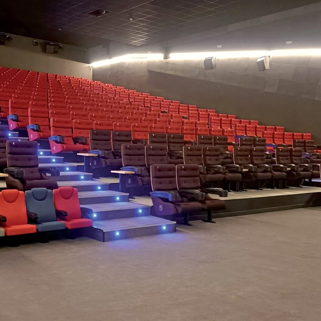 Red Sofía cinema seats on stadium rows with lit steps